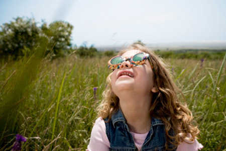 Girl looking up at sun